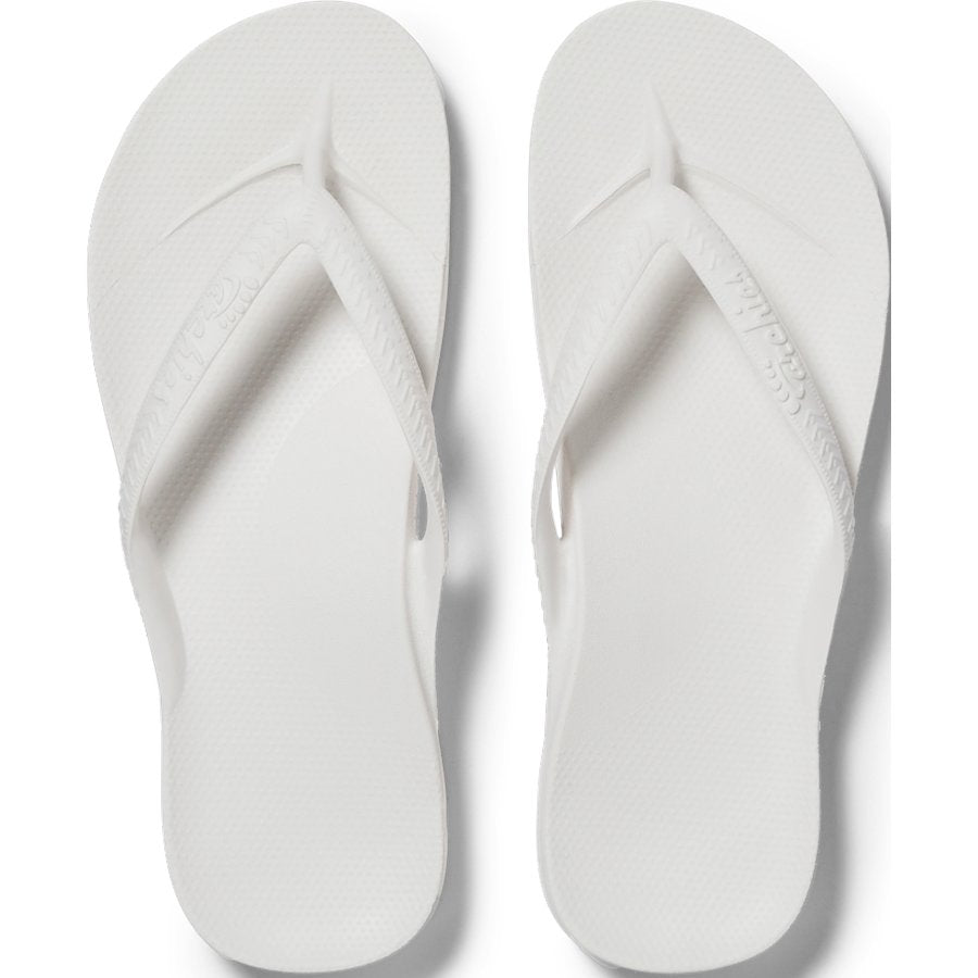 Pair of white flip-flops on a light gray background