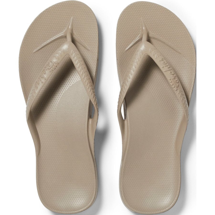Pair of beige flip-flops on a white background