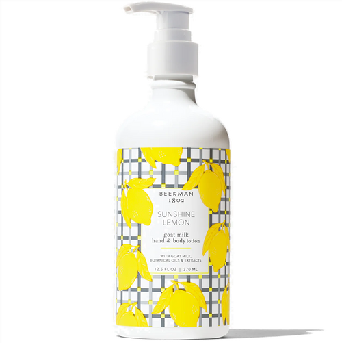 Bottle of Beekman 1802 Sunshine Lemon goat milk hand & body lotion with yellow lemon illustrations on a white background.