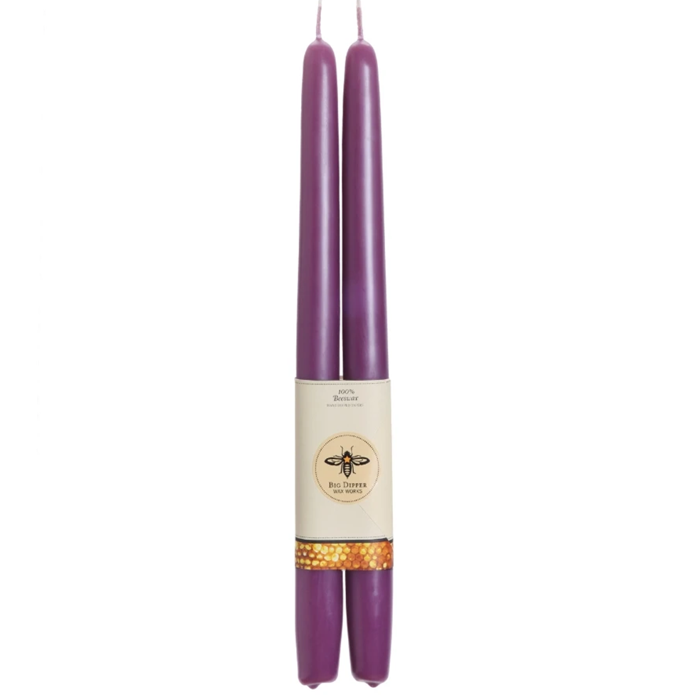 Two purple candles with a label on a white background