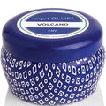 Capri Blue Volcano candle with blue lid and patterned container on a white background