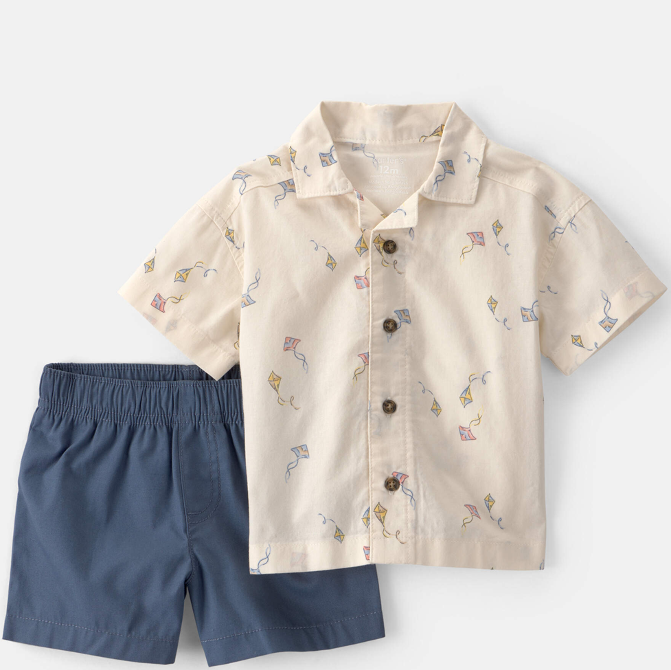 Children's shirt with kite pattern and navy shorts on a light gray background