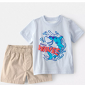 Children's t-shirt with shark graphic and shorts on a light gray background