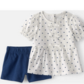 White blouse with blue polka dots and blue shorts on a white background