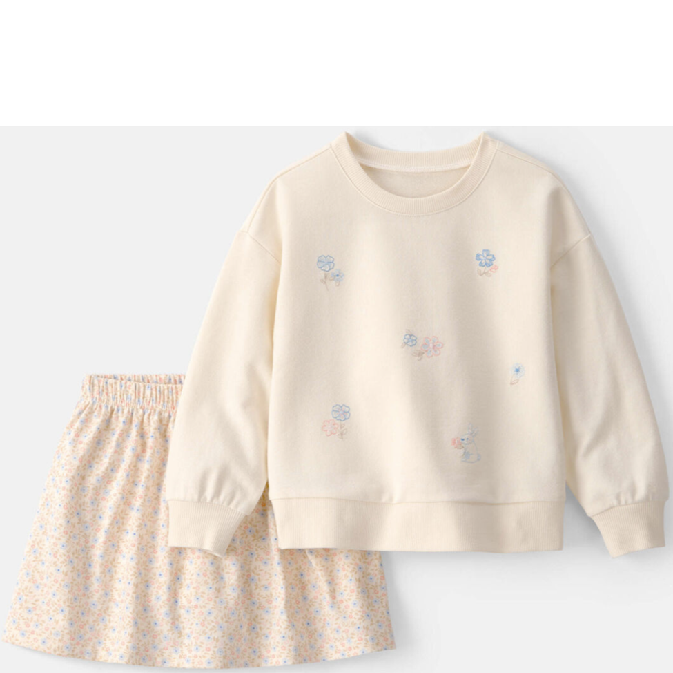 Children's outfit with cream sweatshirt and floral skirt on a white background