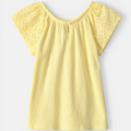 Yellow blouse with floral cut-out sleeves on a light gray background