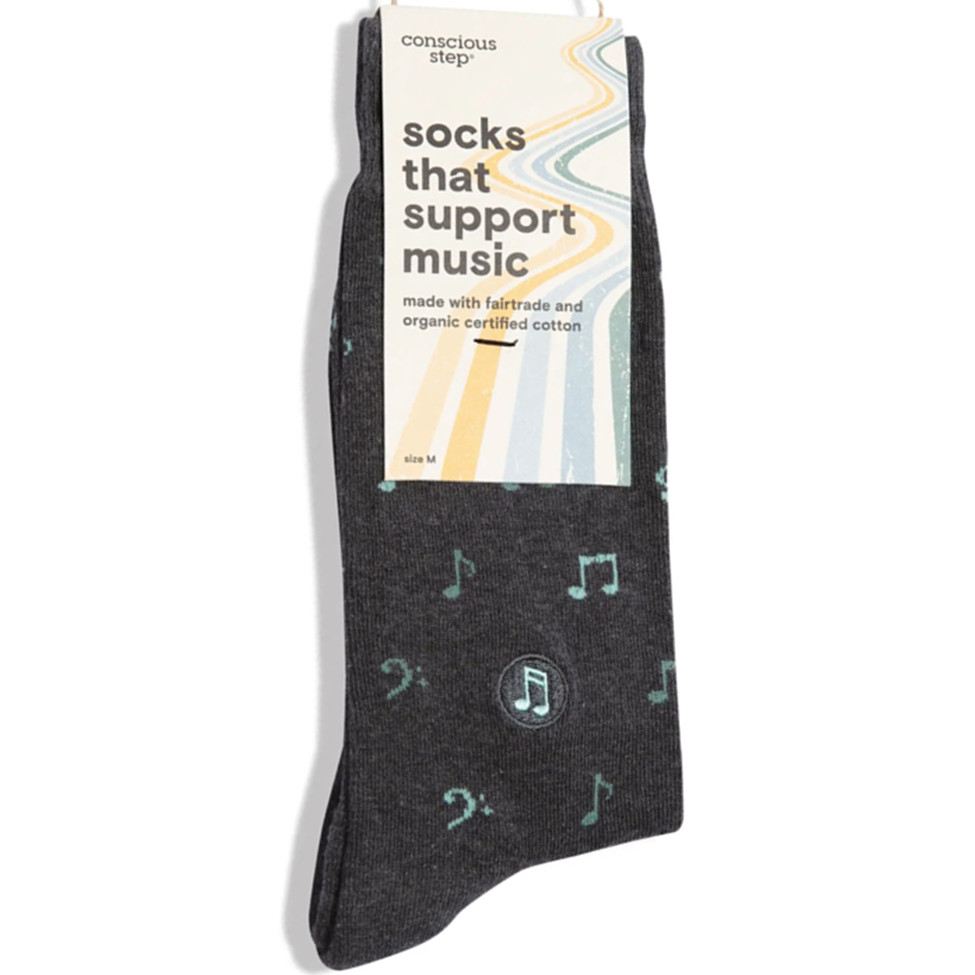 Dark gray socks with musical note designs on a white background, featuring a conscious step branded packaging.
