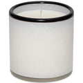 White candle in a marble-textured holder with black rim on a white background