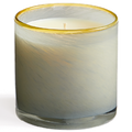 Candle in a glass container with a gold rim on a white background