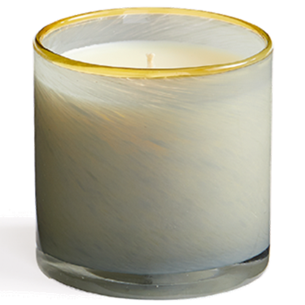 Candle in a glass container with a gold rim on a white background