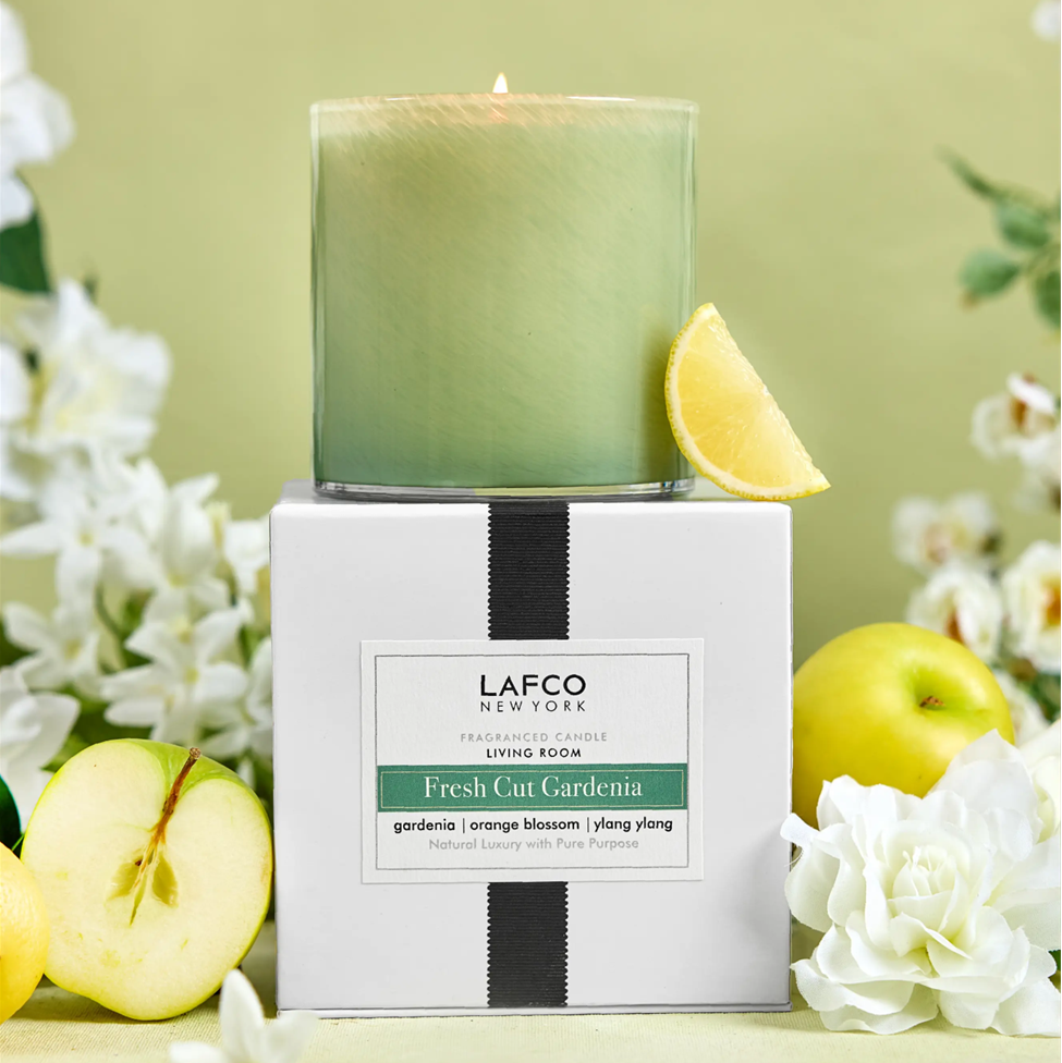 LAFCO Fresh Cut Gardenia candle with apples and flowers on a green background