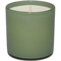 Green candle in a cylindrical container on a white background