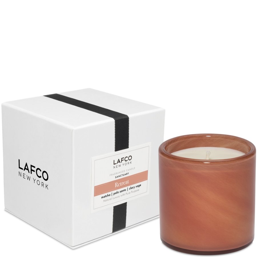 Ceramic candle with terracotta finish next to its packaging on a white background