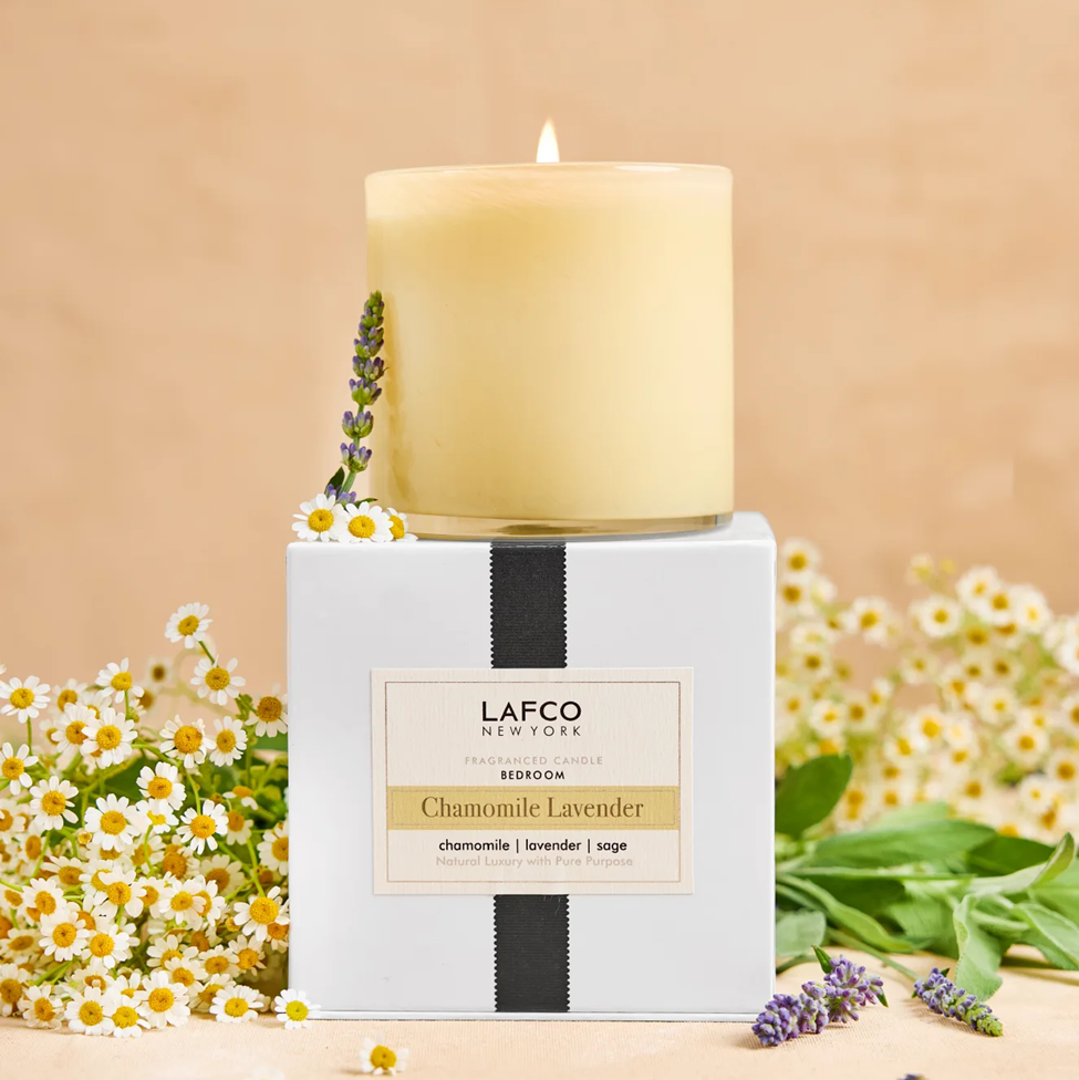Lafco Chamomile Lavender candle on a beige background with flowers around