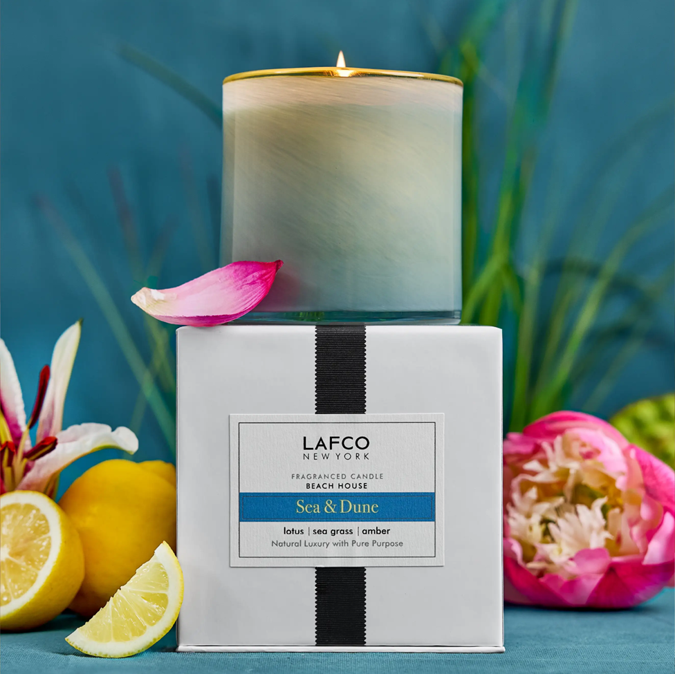 Lafco candle with packaging on a blue background with lemons and flowers