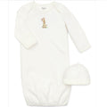 White baby onesie with long sleeves and matching hat on a white background
