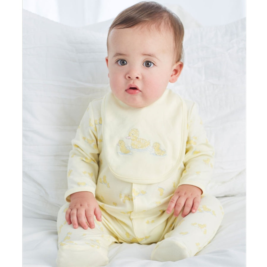 Baby wearing a yellow onesie with a design on a white background
