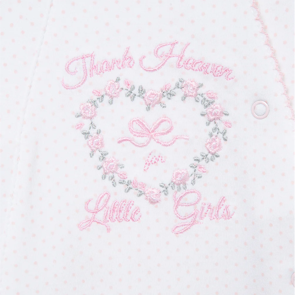 Embroidered design with floral wreath and text on a light pink background