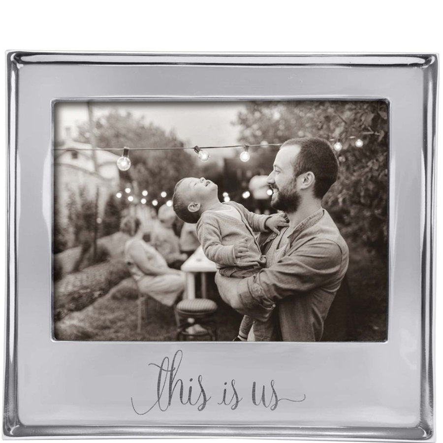 Silver photo frame with a black and white photo of a man holding a child outdoors.