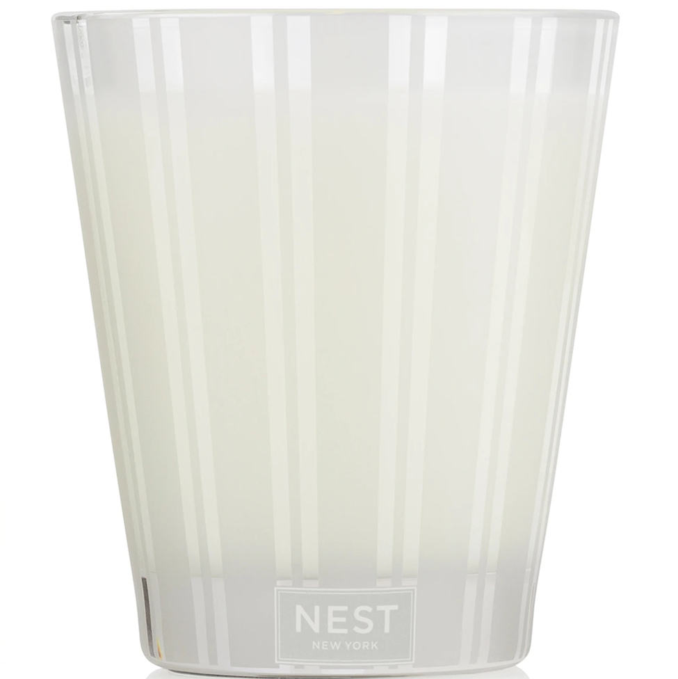 Clear glass candle with 'NEST New York' branding on a white background