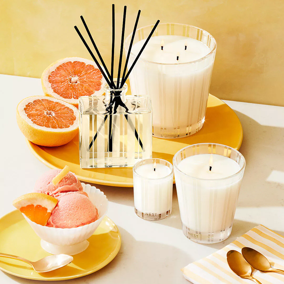 Candle and diffuser set with grapefruit on a yellow plate