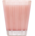 Pink candle in a glass container with 'NEST' branding on a white background