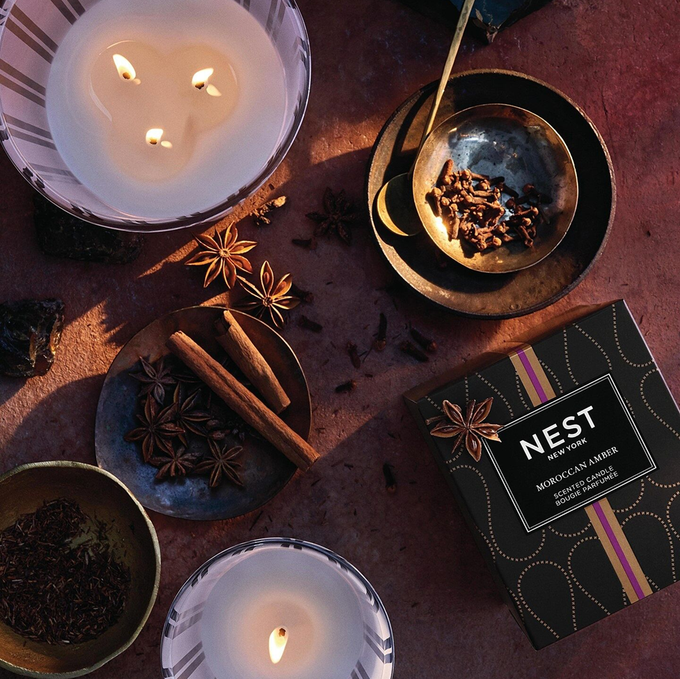 Candles and spices with a NEST Moroccan Amber candle box on a wooden surface