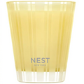 Yellow candle in a glass container with 'NEST New York' branding on a white background