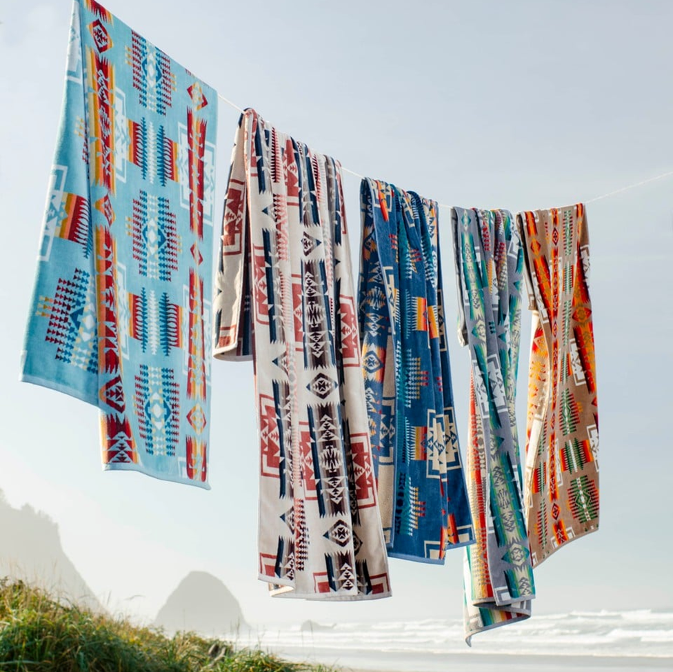 Colorful patterned towels hanging outdoors with a clear sky background