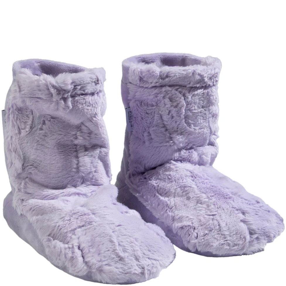 Pair of fluffy purple slippers on a white background