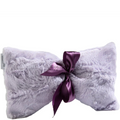 Fluffy pillow with a purple satin bow on a white background