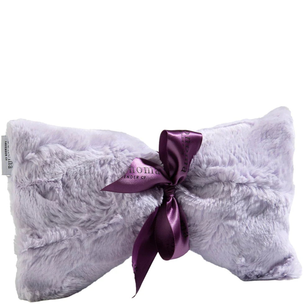 Fluffy pillow with a purple satin bow on a white background