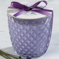 Decorative candle with a purple ribbon on a white background