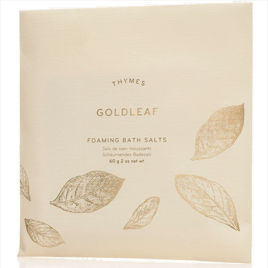 Beige packaging of Thymes Goldleaf Foaming Bath Salts with leaf designs.