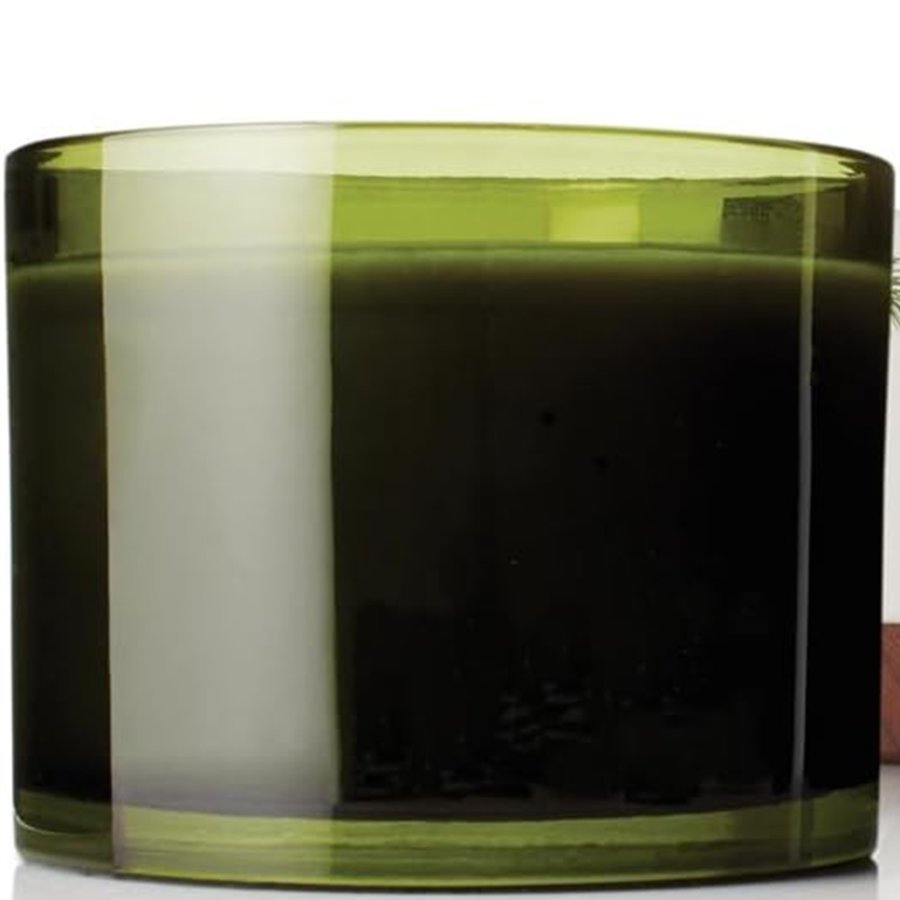 Green glass candle with a white interior on a white background