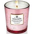 Pink Voluspa candle with a label on a white background