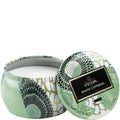 Decorative candle in a tin with a patterned lid on a white background