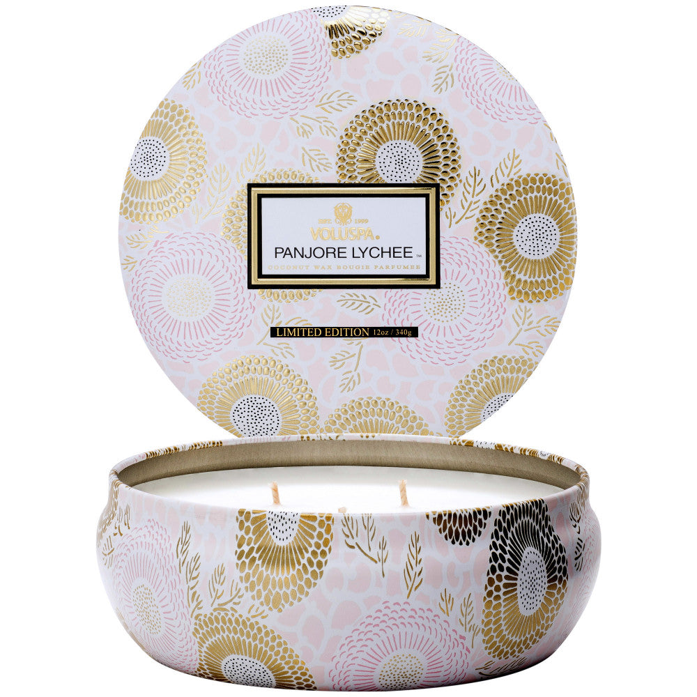 Decorative candle in a tin with floral pattern and 'Panore Lychee' branding.