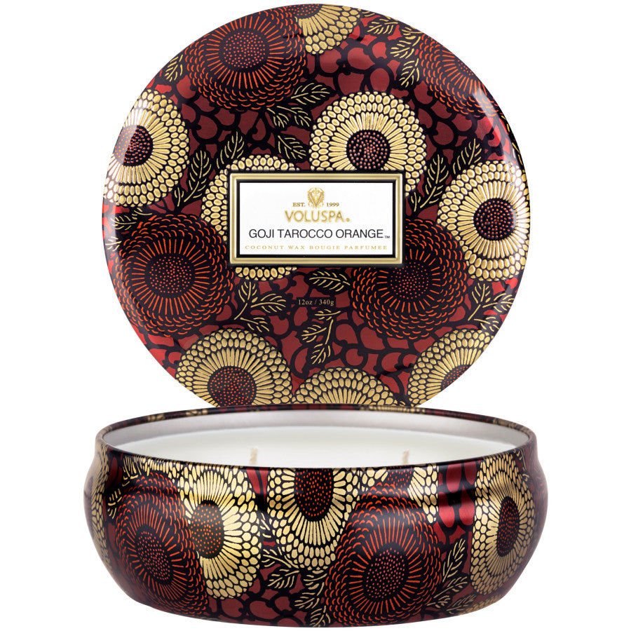 Decorative candle with a patterned lid and base on a white background