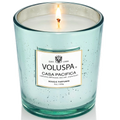 Lit Voluspa Casa Pacifica candle in a speckled glass container on a white background