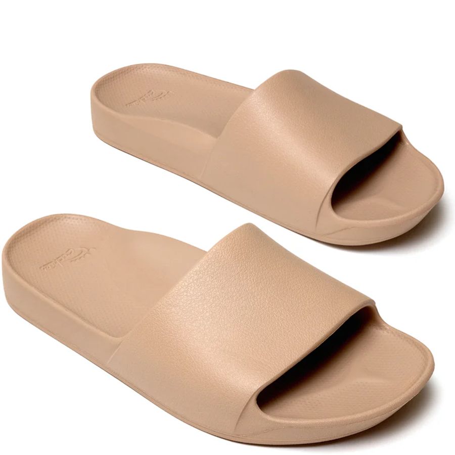 Pair of beige slides on a white background