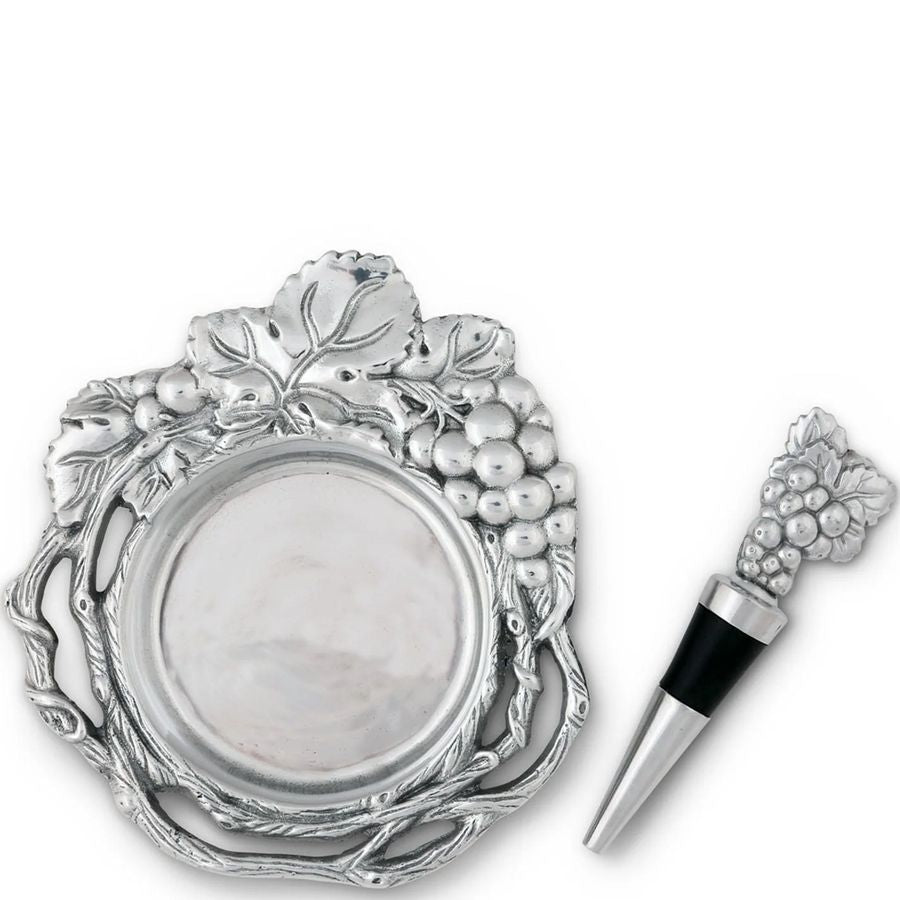 Decorative silver wine bottle stopper with grape design on a white background