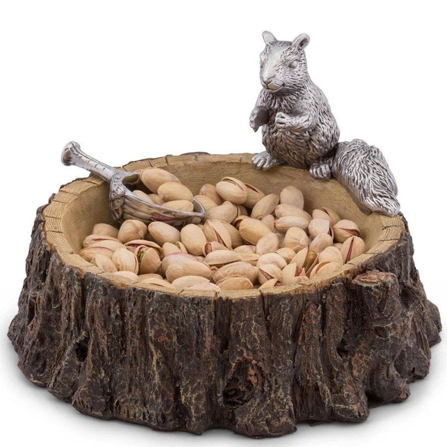 Decorative bowl with a squirrel figurine and pistachios on a white background