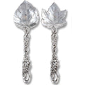 Pair of silver spoons with leaf and vine designs on a white background