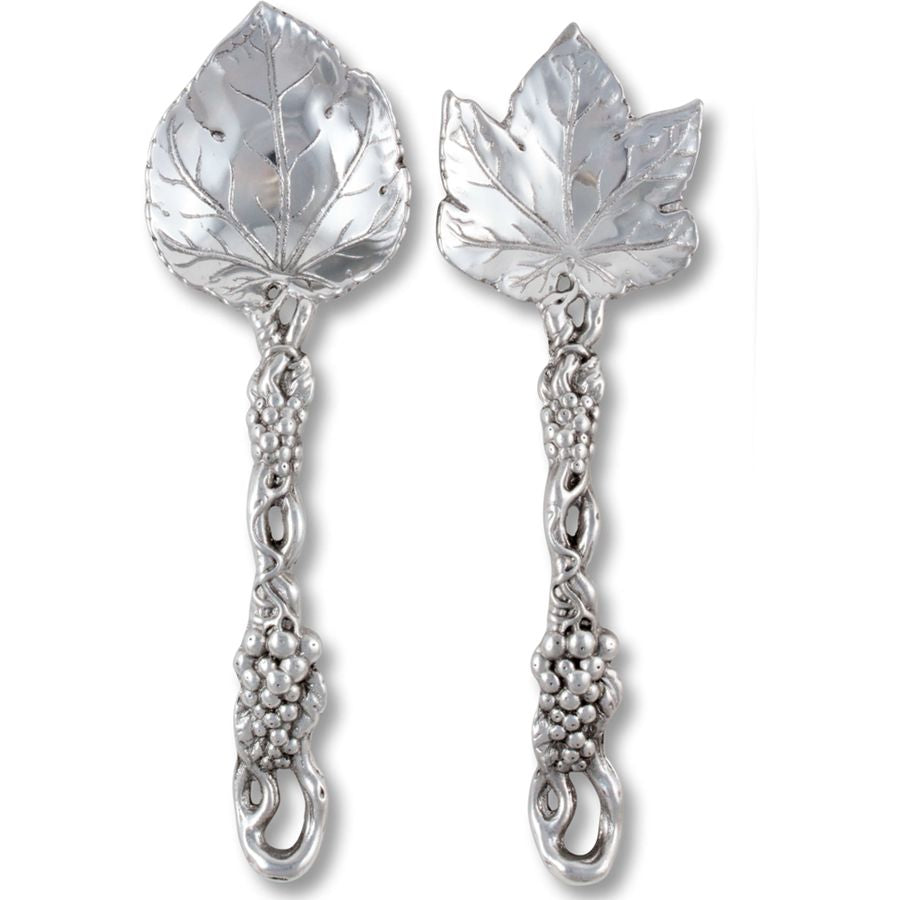Pair of silver spoons with leaf and vine designs on a white background