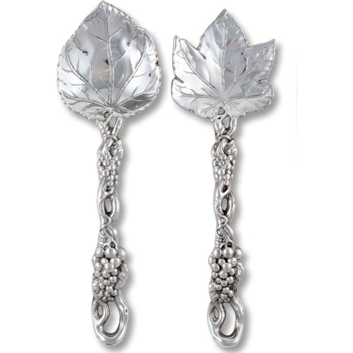 Pair of silver spoons with leaf and vine designs on a white background