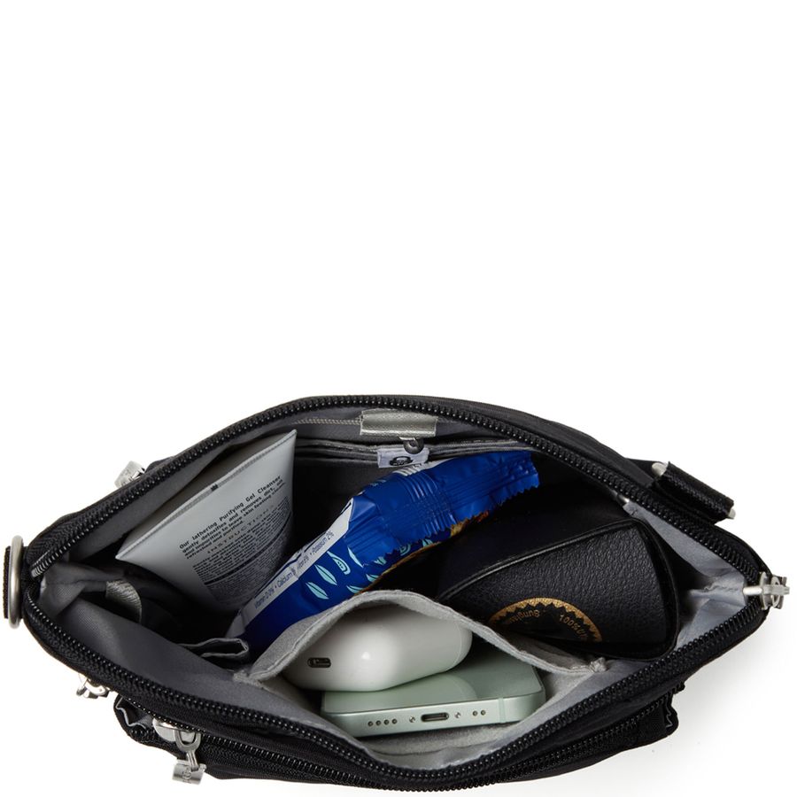 Black crossbody bag with compartments containing electronic devices on a white background