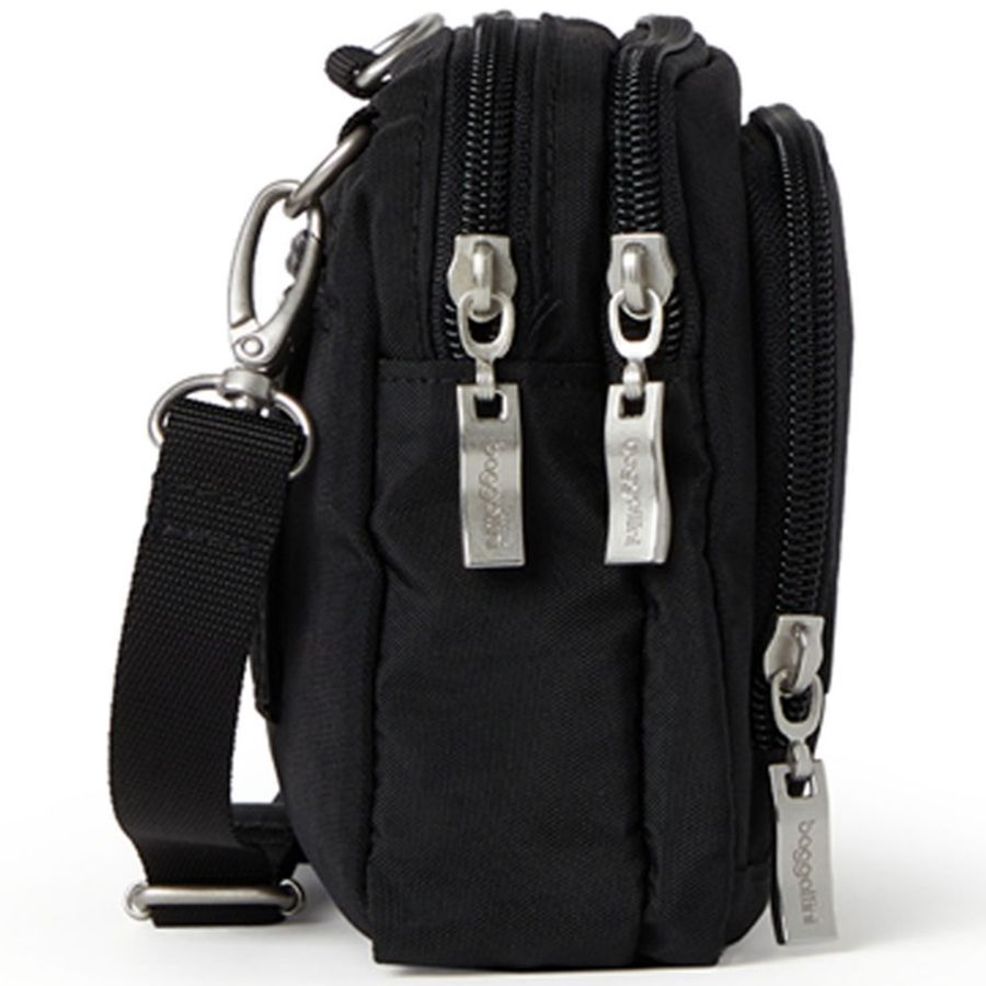 Black crossbody bag with multiple zippers on a white background