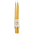Two yellow candles with a label on a white background