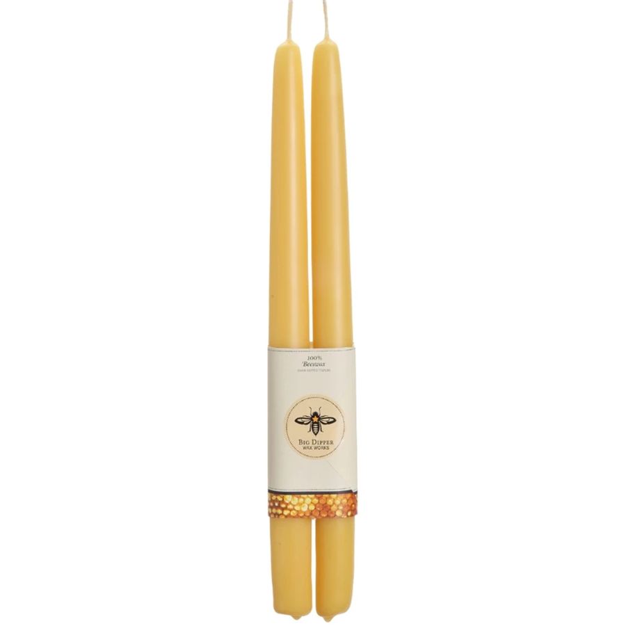 Two yellow candles with a label on a white background